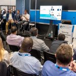 IFSEC panel discussion with man on microphone, three speakers and seated audience