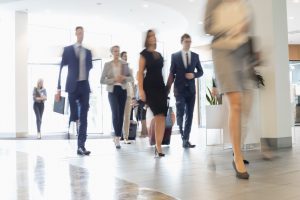 Blurred image of business people moving through office space